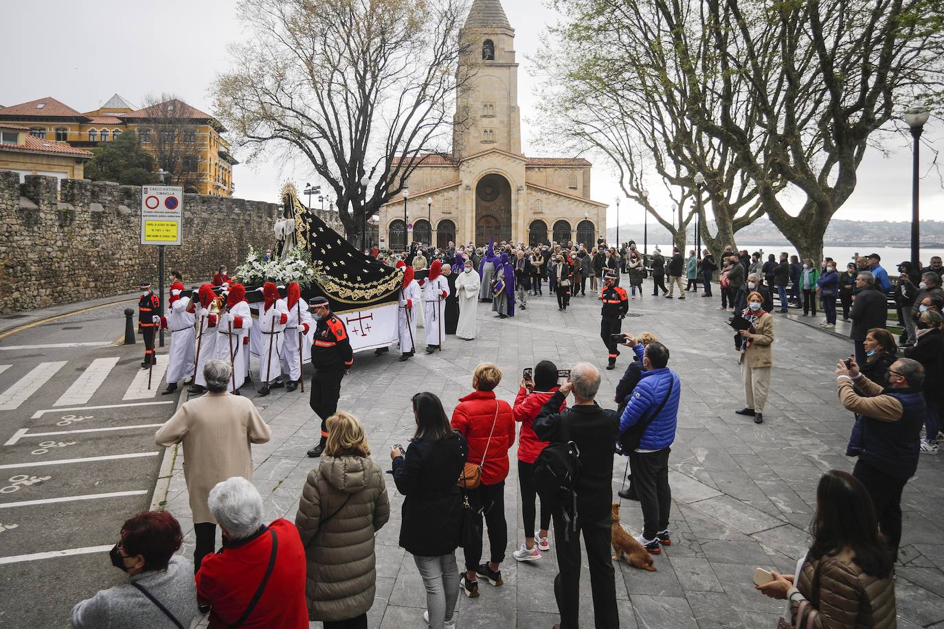 La Ilustre Hermandad de la Santa Vera Cruz abrió camino desde el Campo Valdés para dirigirse a Sebastián Miranda, seguidos por la Hermandad de la Misecordia, portadora de la imagen de San Juan Evangelista y, tras ellos, los integrantes de la Ilustre Cofradía del Santo Sepulcro portaban sobre sus hombros a la virgen de la Soledad, rodeada de flores blancas y ataviada con un manto azul noche y bordados dorados.