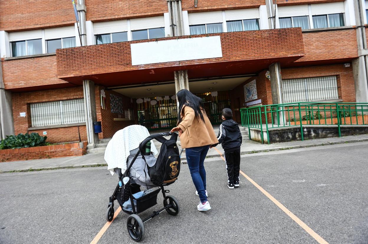 Una madre deja a su hijo mayor a la entrada del colegio de Villafría, en Oviedo. 
