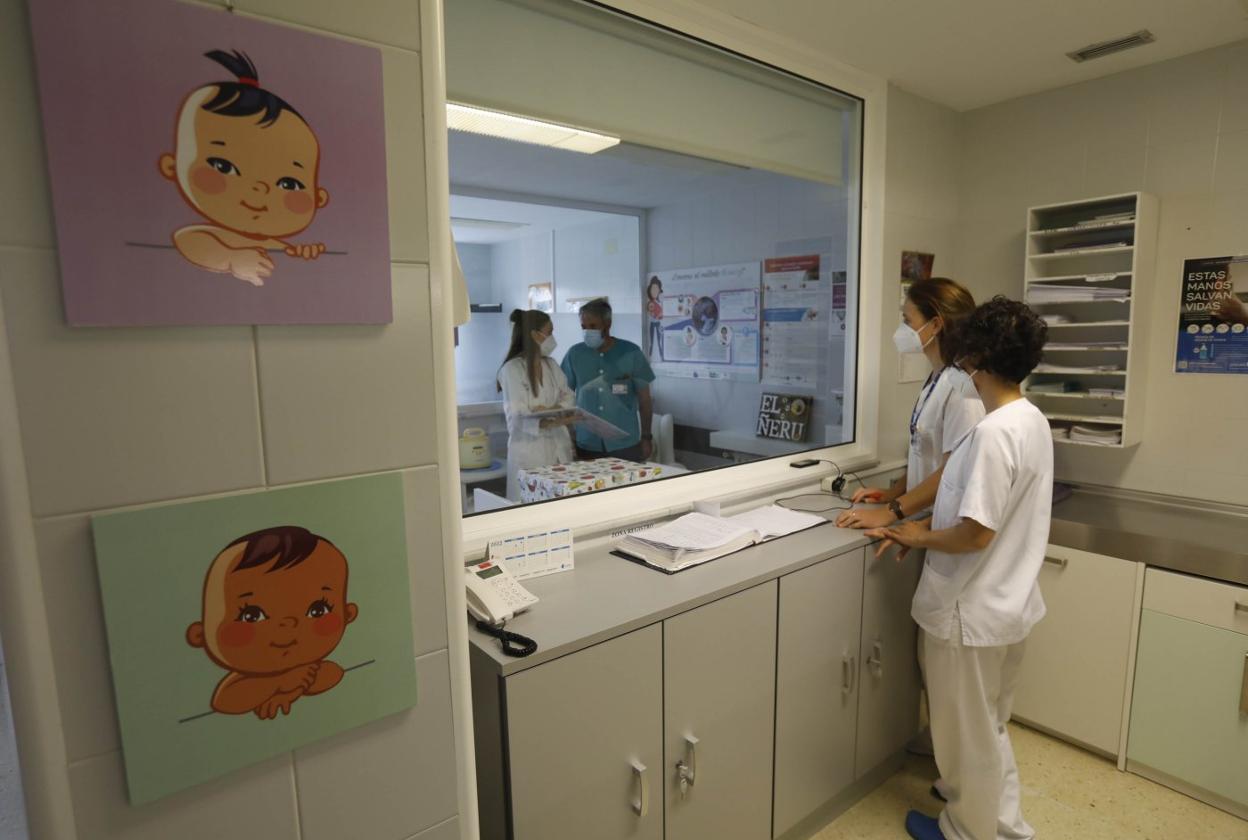 Al fondo, la matrona y supervisora de la segunda planta impar, Nuria Madueño charla con el jefe de sección de Obstetricia en 'El Ñeru', la nueva sala de lactancia. A este lado del cristal (la visión se puede ocultar con una cortina), las enfermeras María González y Laura García. 