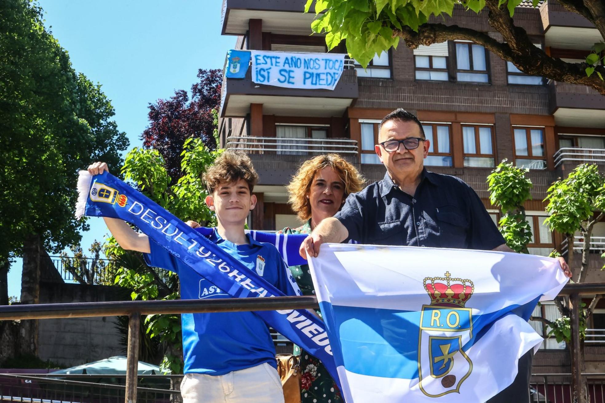 Lucas, junto a su madre Patricia y Julio, presidente de la Peña Azul Cadillac, con una pancarta colgada de la terraza del domicilio del joven aficionado.