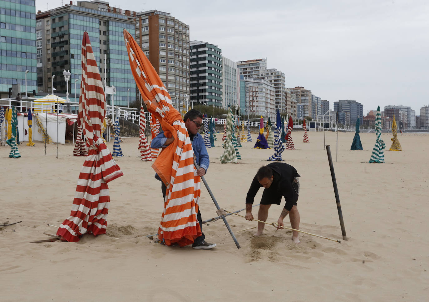 Las 115 casetas autorizadas por la Demarcación de Costas de Asturias para la playa de San Lorenzo ya se encuentran apiladas en el arenal gijonés. Después de dos años de ausencia por las restricciones derivadas de la pandemia sanitaria, las icónicas casetas comenzaron a instalarte este lunes en las escaleras 7, 12 y 14.