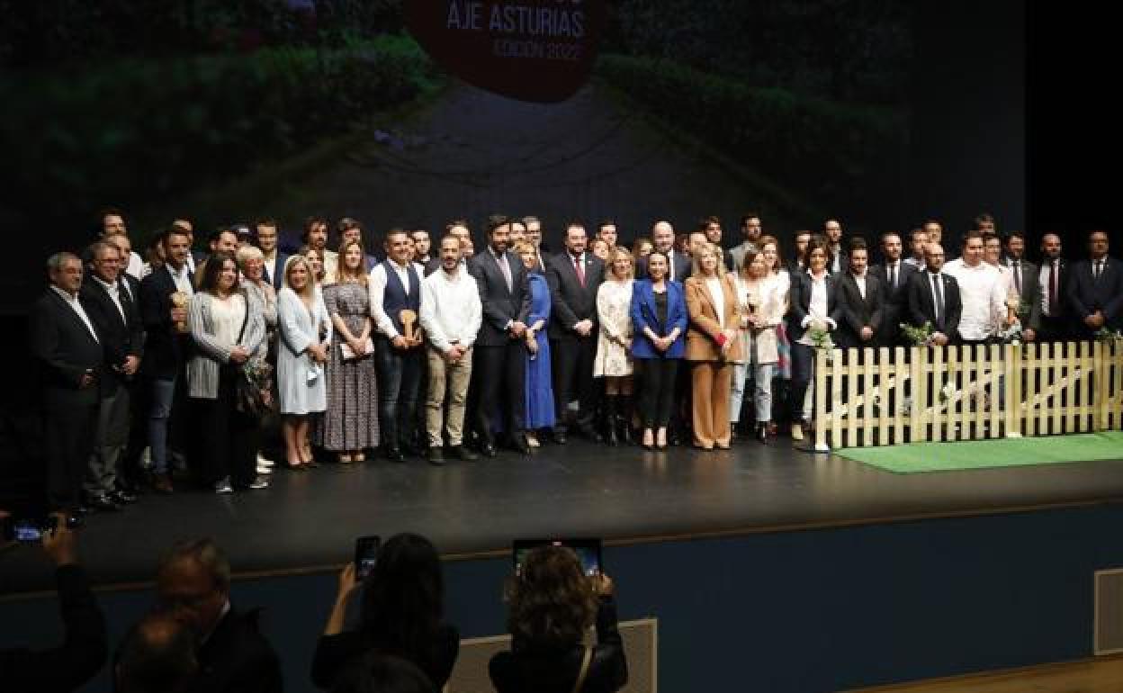 Foto de familia de los premiados y candidatos de la Fundación de Jóvenes Empresarios sobre el escenario del Centro Polivalente de Lugones. 