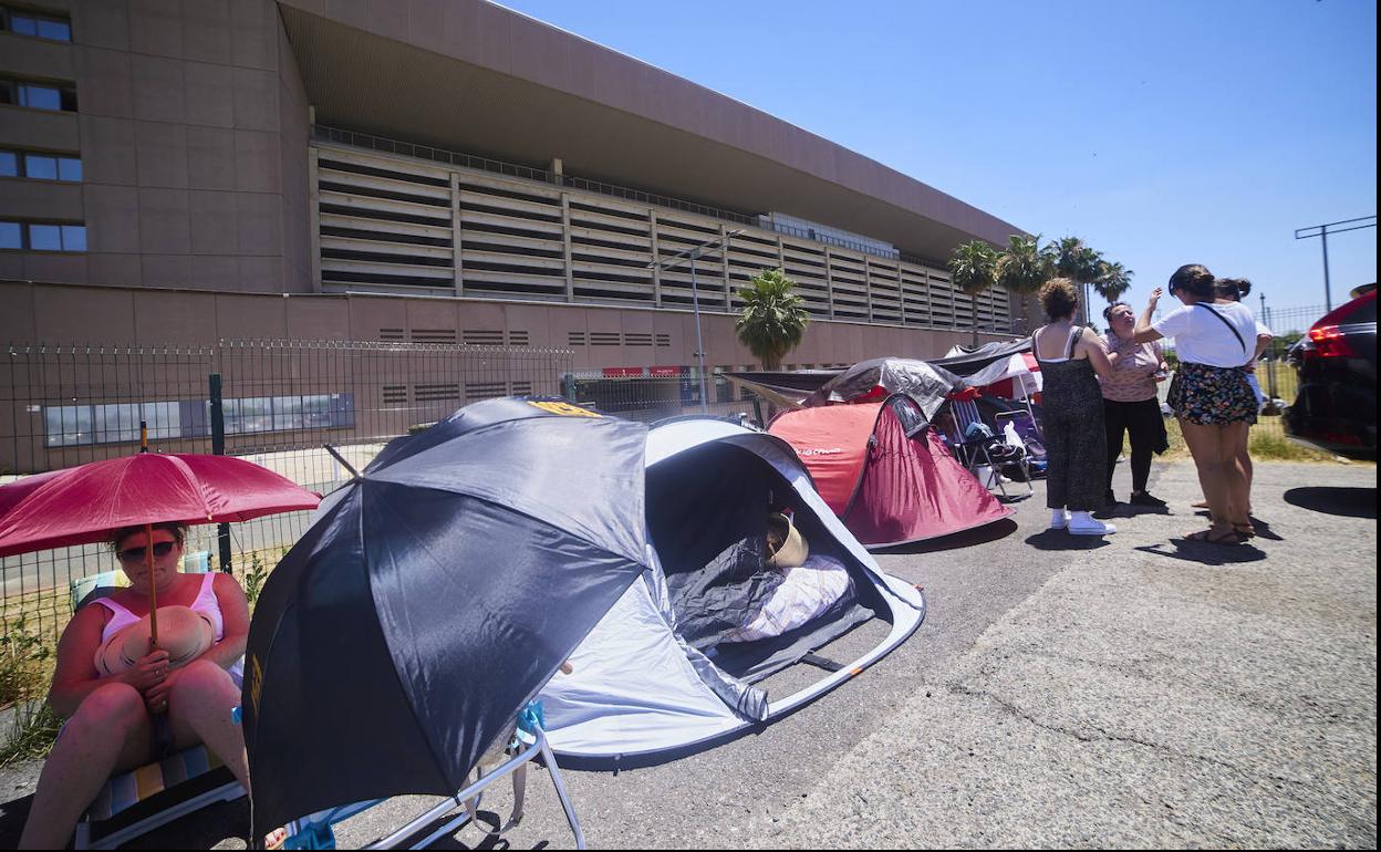 Una veintena de personas, en plena ola de calor, hacen cola para el concierto de Manuel Carrasco en Sevilla.