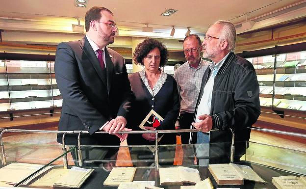 Adrián Barbón y Berta Piñán, con el arqueólogo César García de Castro y Juan Miguel Menéndez Llana, director de la Biblioteca Pública de Asturias Ramón Pérez de Ayala, ante una de las vitrinas de la muestra, comisariada por ambos.