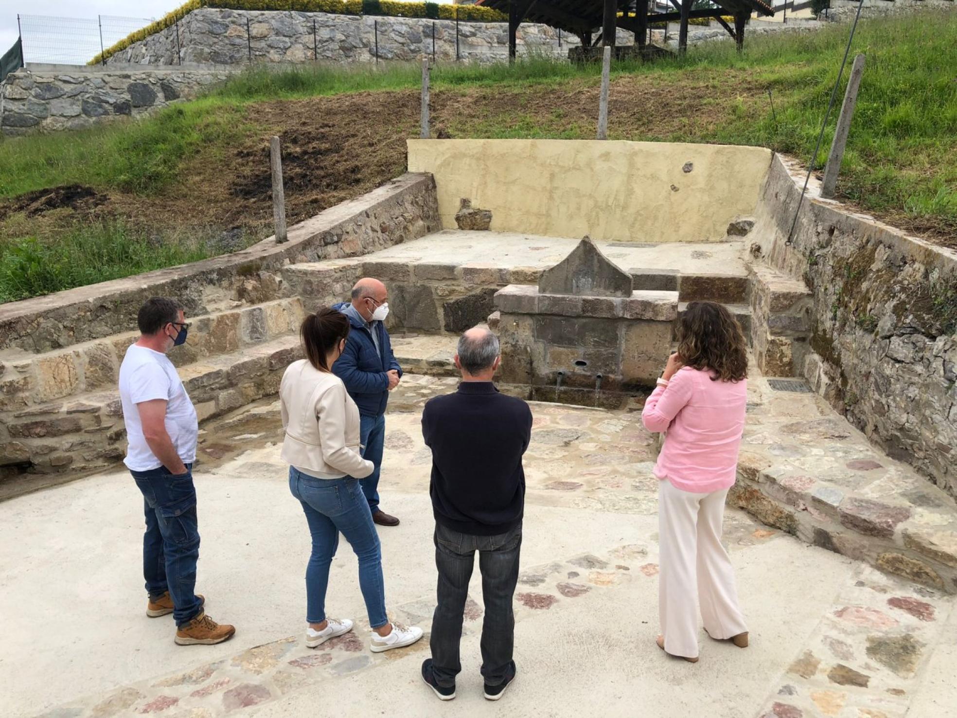 El equipo de gobierno y los vecinos en una visita a la fuente centenaria de Cuero. 