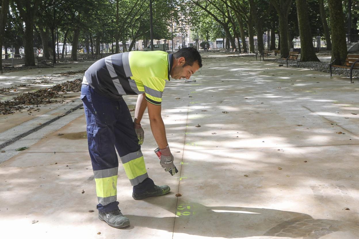 Un operario marca los puestos de venta de productos de la huerta que estrenarán el nuevo parque el lunes. 