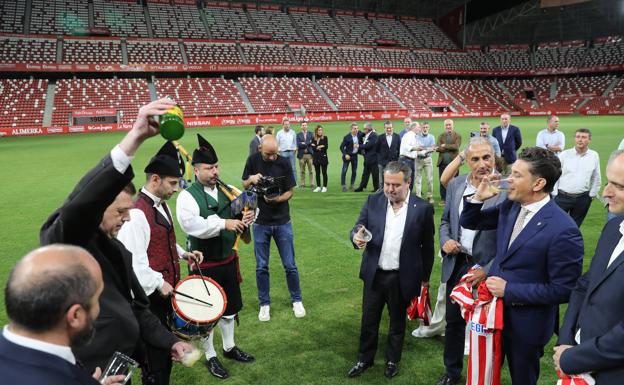 Imagen. El presidente del grupo Orlegi, Alejandro Irarragorri, bebe un culín de sidra tras su primera rueda de prensa en El Molinón.