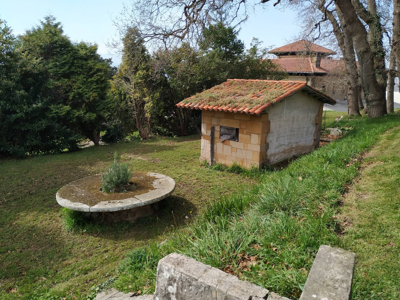 Mesona de piedra, la única redonda que se conoce en el municipio de Gijón, y el antiguo gallinero a su derecha.