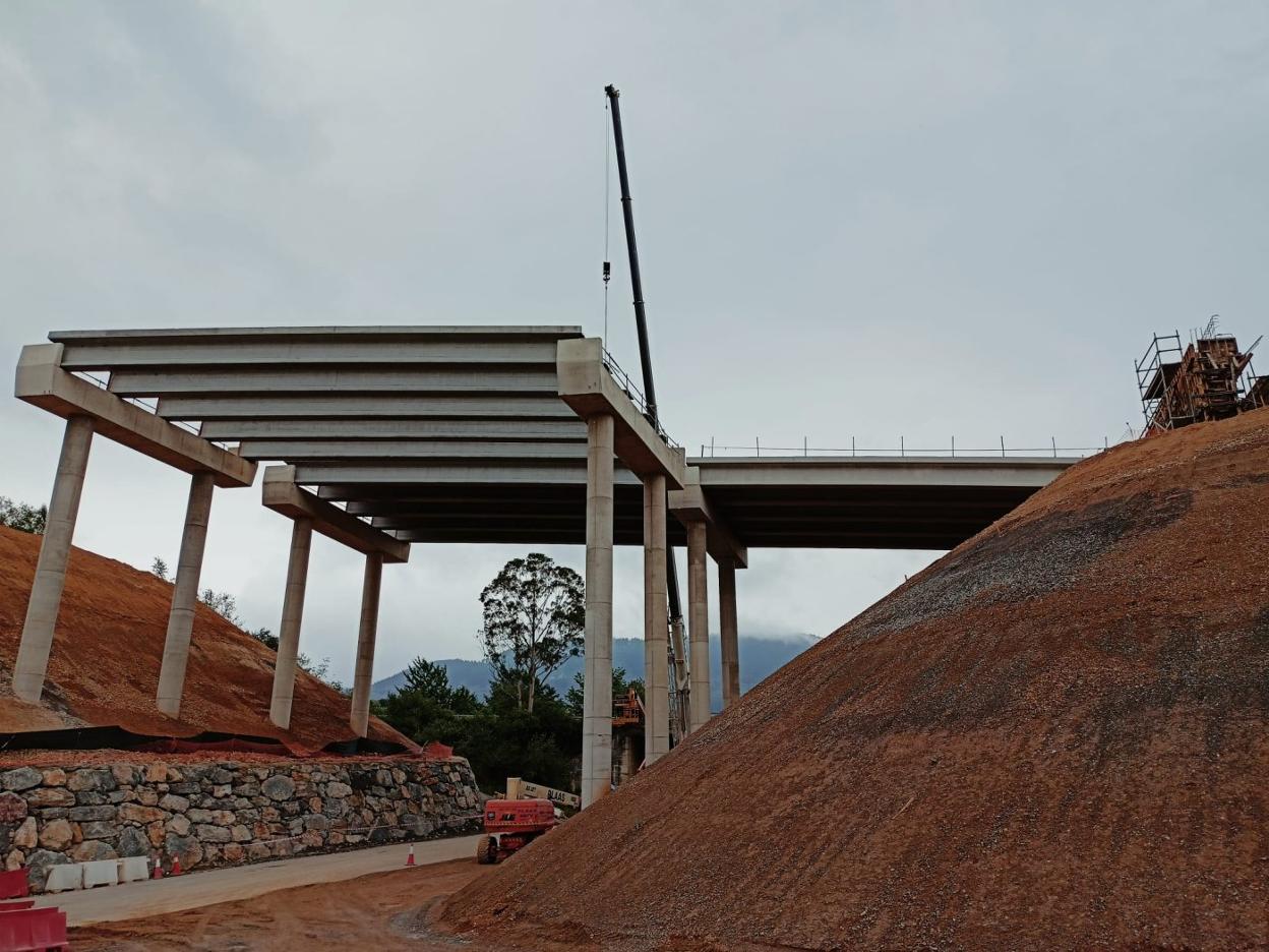 La grúa telescópica, con un brazo de varios metros de longitud, instala las placas sobre las que se asentará la calzada en el puente de La Barrosa. 