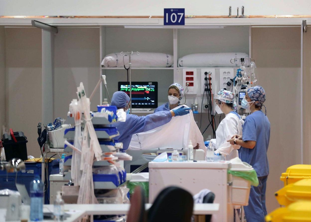 Sanitarias del HUCA atienden a un paciente en la UCI que se instaló en el gimnasio del hospital, en febrero del año pasado. 