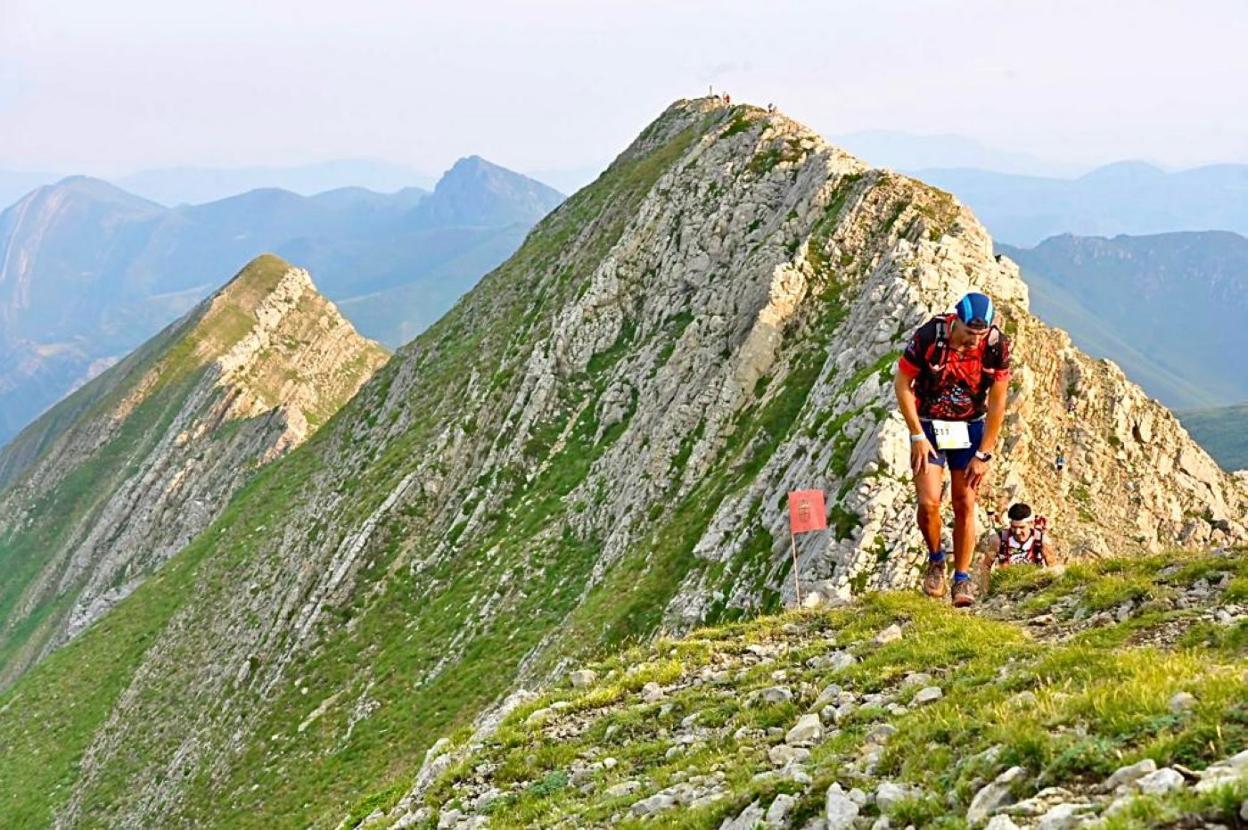 Dos participantes, exhaustos, en la subida a una de las montañas incluidas en el recorrido. 