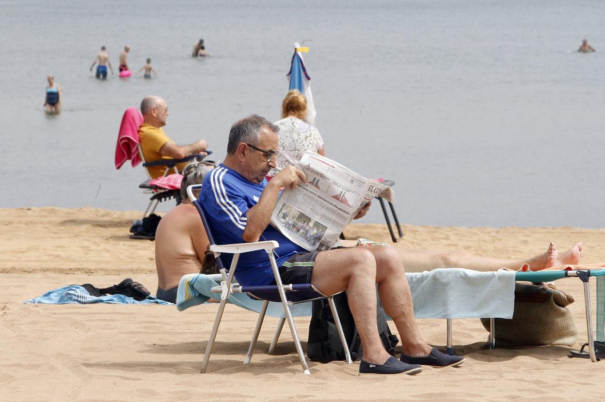 Un lector de EL COMERCIO, al fresco en la playa del Arbeyal de Gijón. 