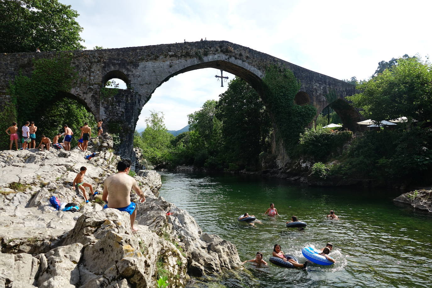 Bajo el Puente Romano de Cangas de Onís, locales y turistas se remojan en días de calor. 