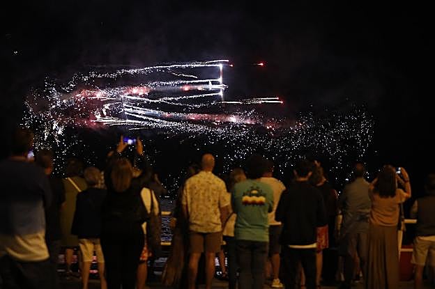 Los aviones del equipo Aerosparx realizan un 'twister' perdiendo altura y con fuegos artificiales sobre el mar Cantábrico. 