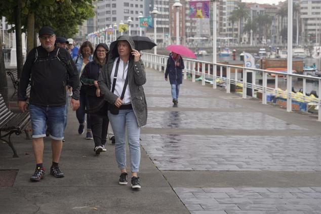 Fotos: Turistas bajo la lluvia asturiana
