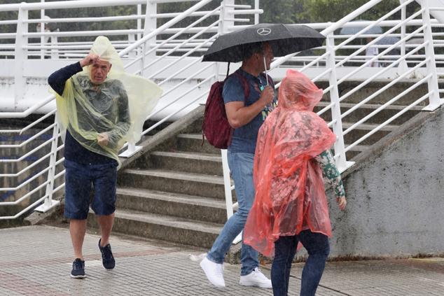 Fotos: Turistas bajo la lluvia asturiana