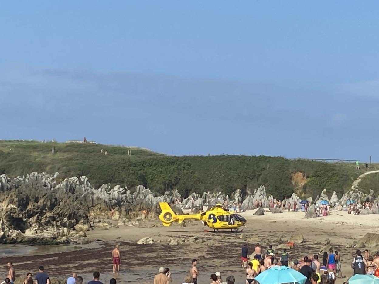 El helicóptero de Bomberos de Asturias, que trasladó a la mujer al HUCA, en la playa de Toró. 