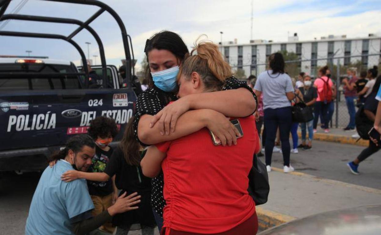 Familiares de reclusos de la cárcel donde se inició el enfrentameinto se abrazan a las afueras del centro