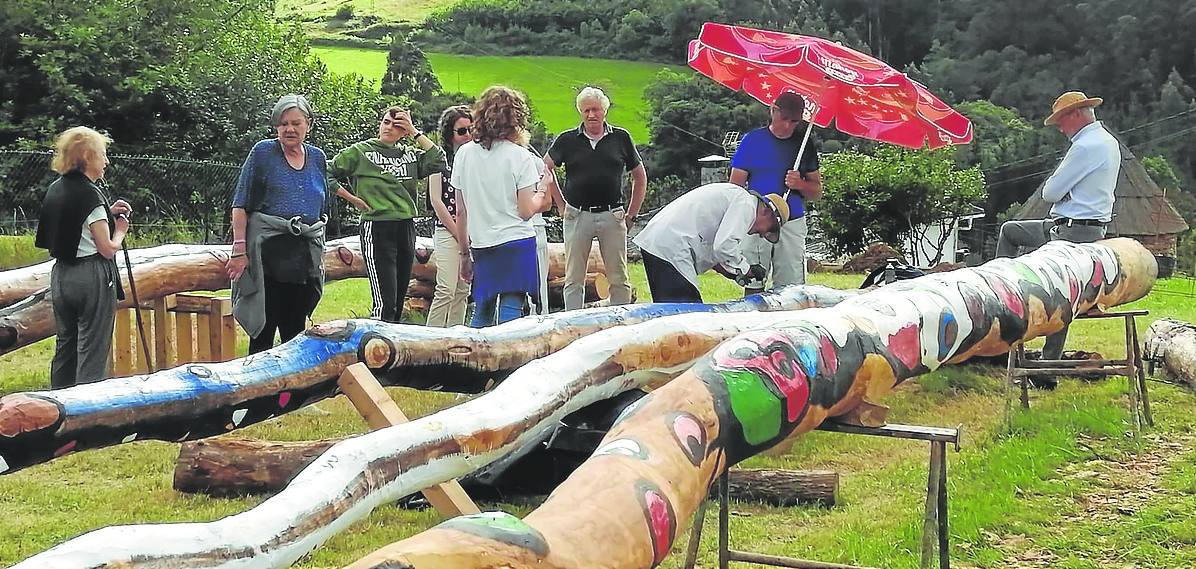 El artista Juan Méjica pinta los castaños, rodeado de vecinos. 