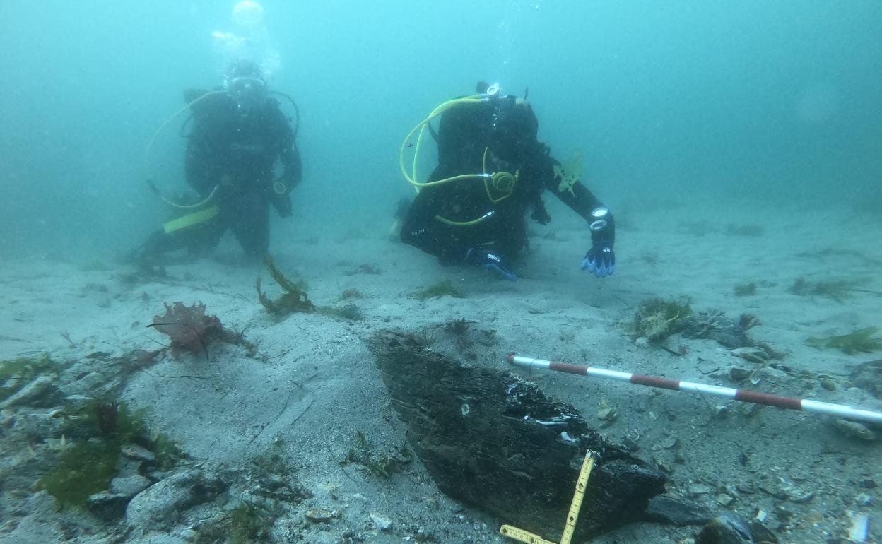 Dos buzos, junto al pecio medieval encontrado en la ría del Eo.