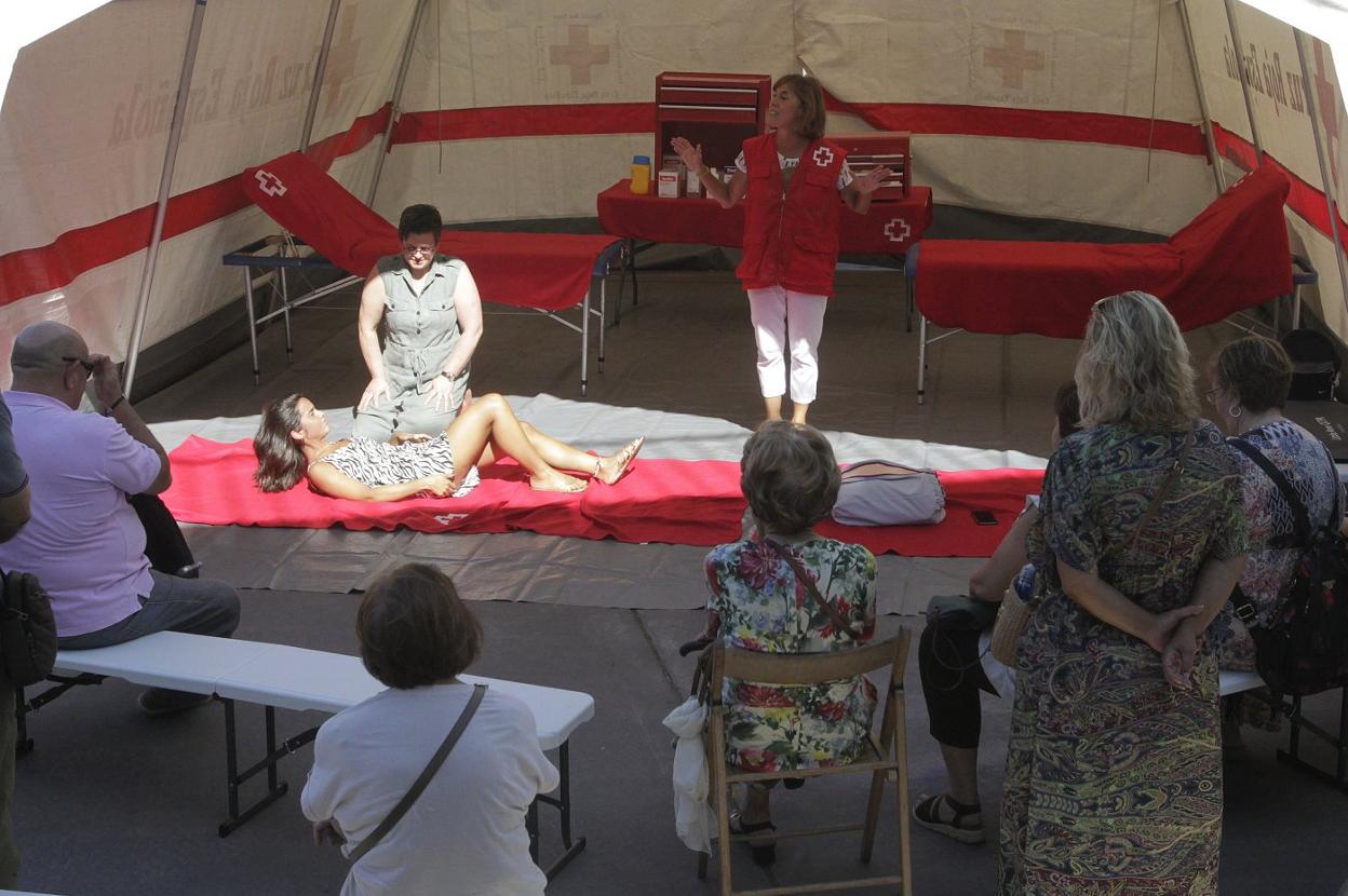 Dos personas de las que asistieron al curso ponen en práctica lo aprendido, delante de la técnico 