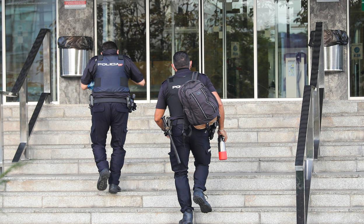 Dos agentes de Policía llegan al Hospital Valle del Nalón donde tomaron declaración al presunto homicida. 