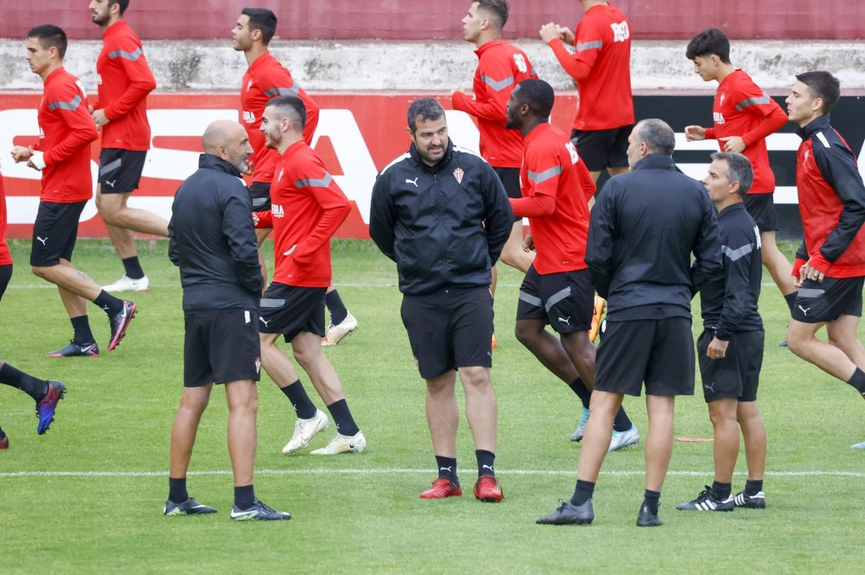 Abelardo, junto a su cuerpo técnico, con los jugadores corriendo al fondo. 