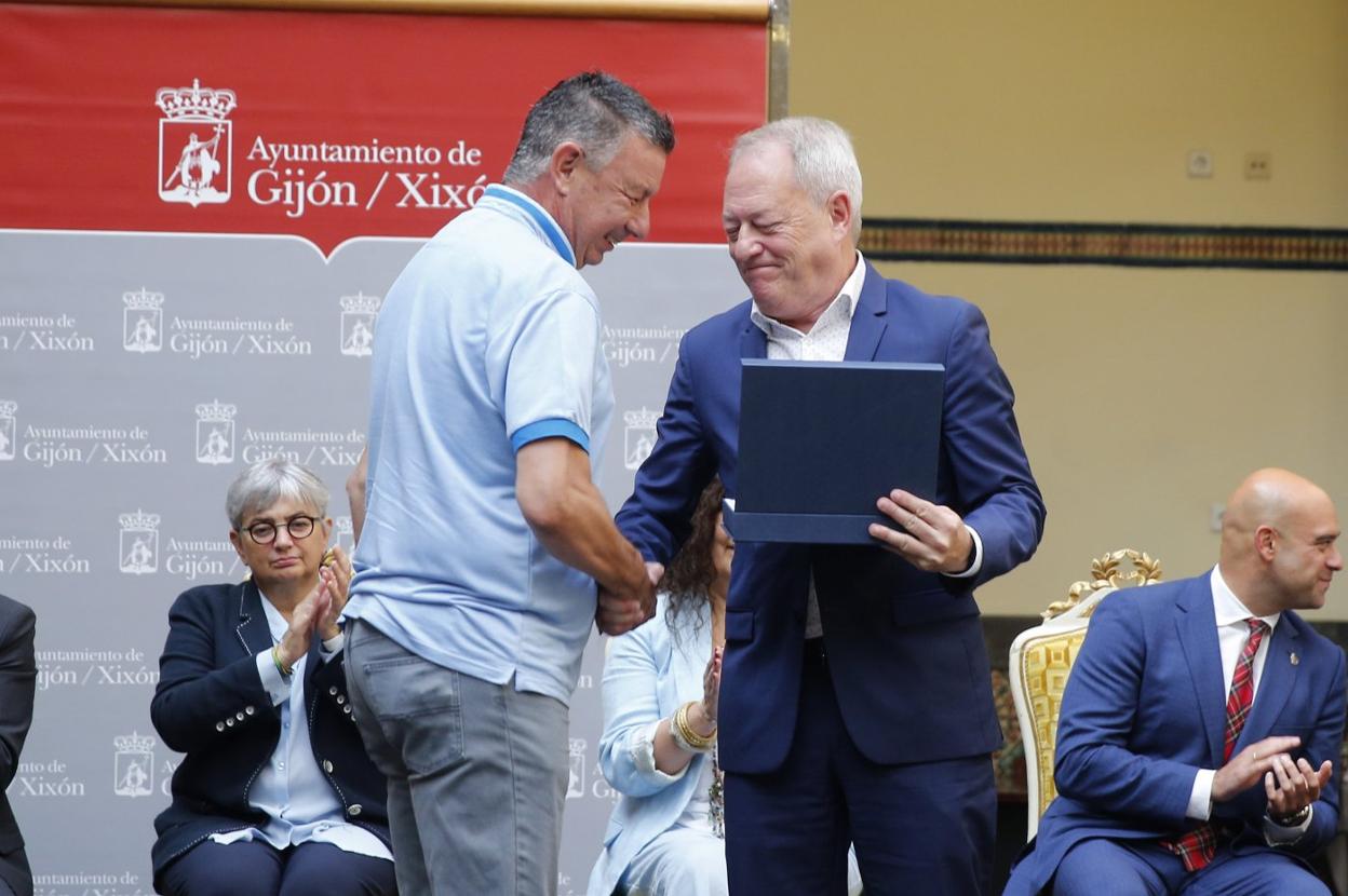 Álvaro Menéndez recibe la distinción de manos de Aurelio Martín. 
