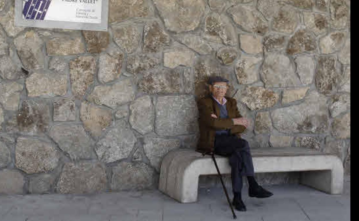 Un jubilado sentado en un banco. 