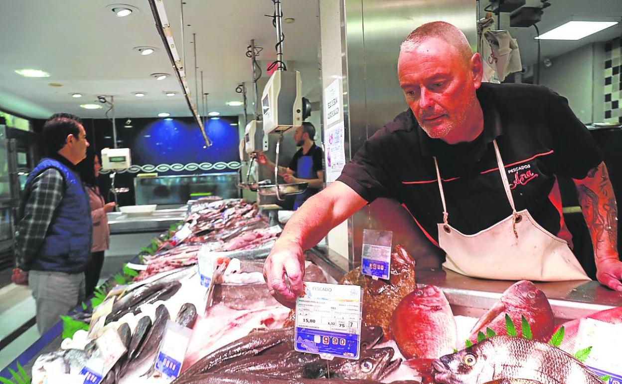 Paco Ropero, gerente de 'Pescados Ana', colocando el mostrador de su negocio.