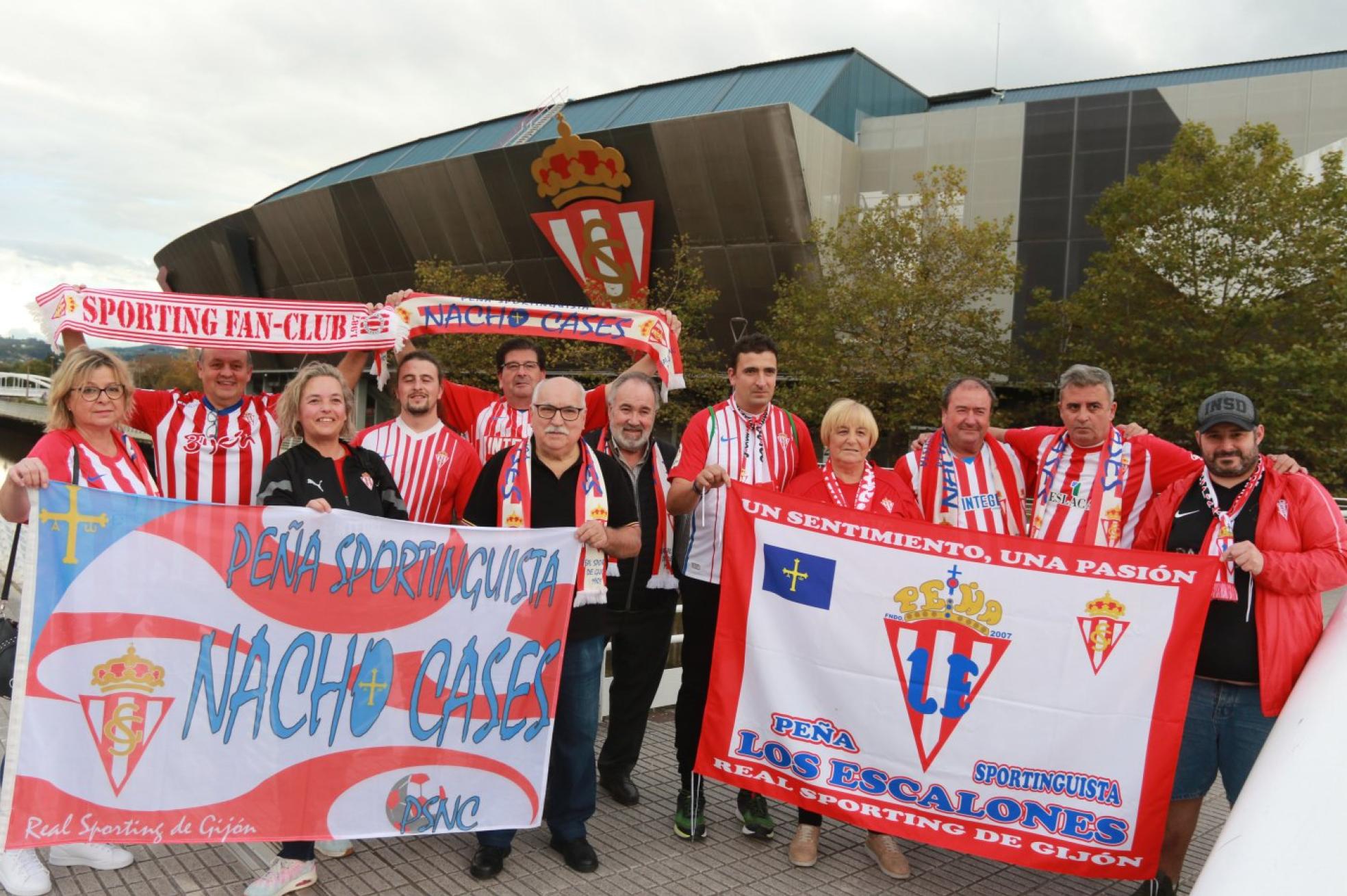 Aficionados de las peñas Sportinguistas Nacho Cases y Los Escalones delante del escudo del Sporting en el estadio de El Molinón. Entre ambas peñas suman cincuenta aficionados desplazados a Vitoria 