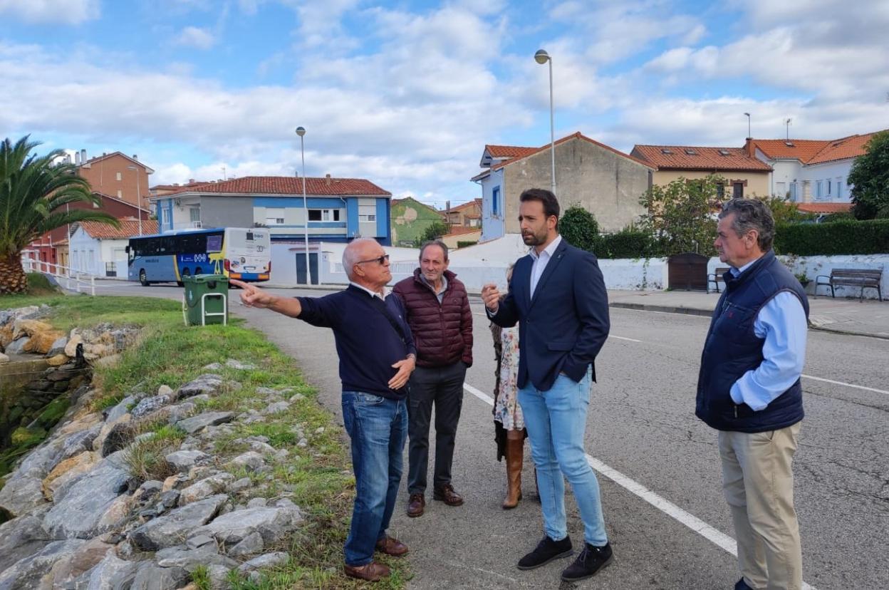 Álvaro Queipo observa el muelle de La Arena flaqueado por vecinos y compañeros de partido. 