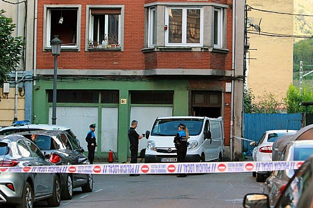 Agentes de Policía, junto al furgón que iba a trasladar el cuerpo de la fallecida. 