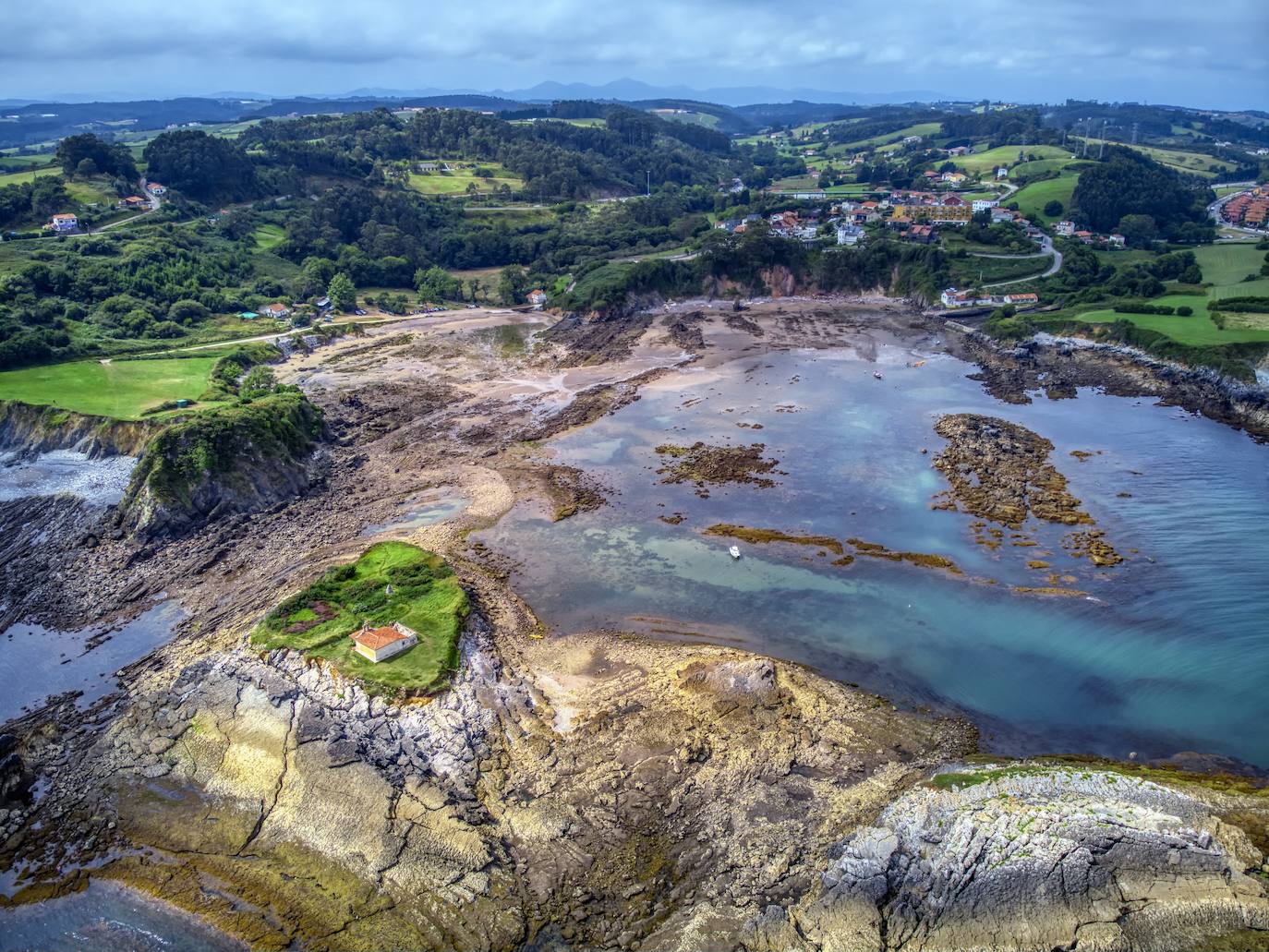 Vista aérea del islote de Peña Cercada en el que se sitúa la ermita del Carmen, que data de 1701. Se dice que en este islote vivió durante muchos años un virtuoso ermitaño de nombre Santos y cuando la marea baja puede accederse al islote caminando. 