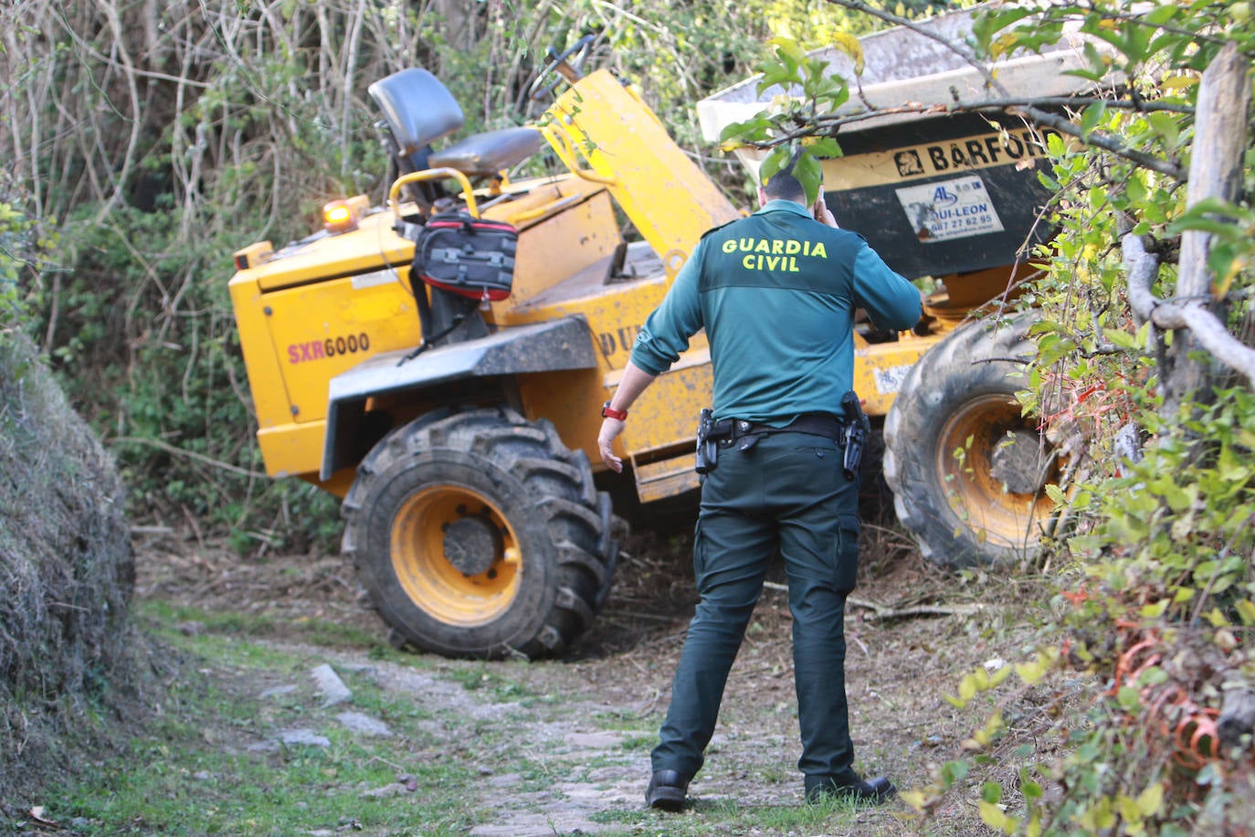 Un agente de la Guardia Civil junto al dúmper accidentado. 