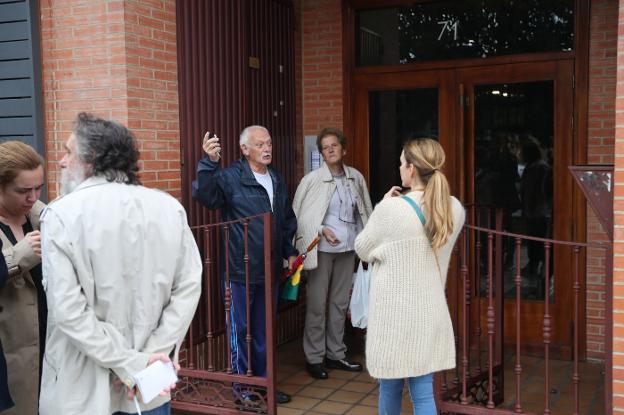 Dos vecinos de la madre y la pequeña fallecida hablan con los periodistas en el portal. 