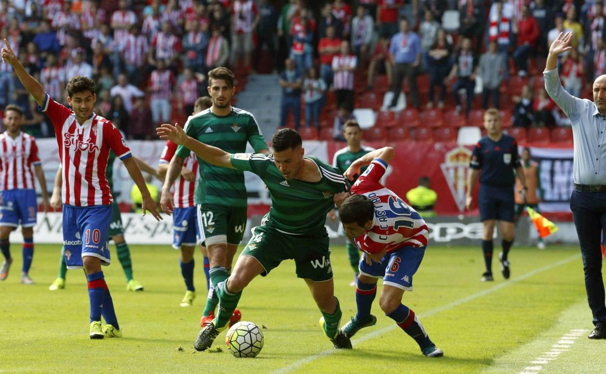 Bruno, en su etapa con el Betis, protege el balón ante la presión de Carlos Castro, con Abelardo siguiendo la jugada en la banda.