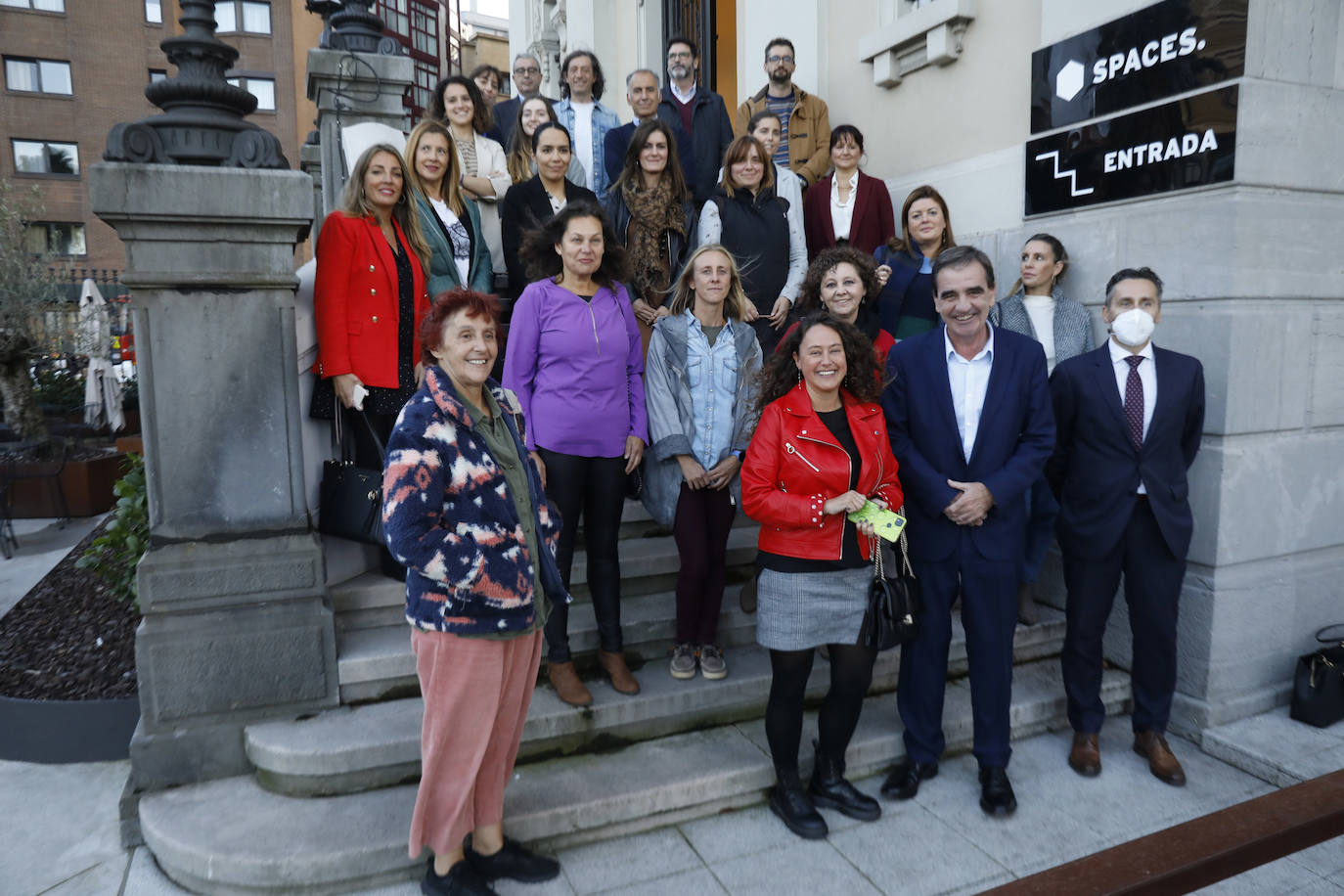 Representantes de los siete centros educativos que participan en la iniciativa, de las entidades colaboradoras y el equipo de la Escuela de Periodismo de EL COMERCIO, en la escalinata de entrada a la sede del diario, en el edificio Spaces de Gijón. josé simal