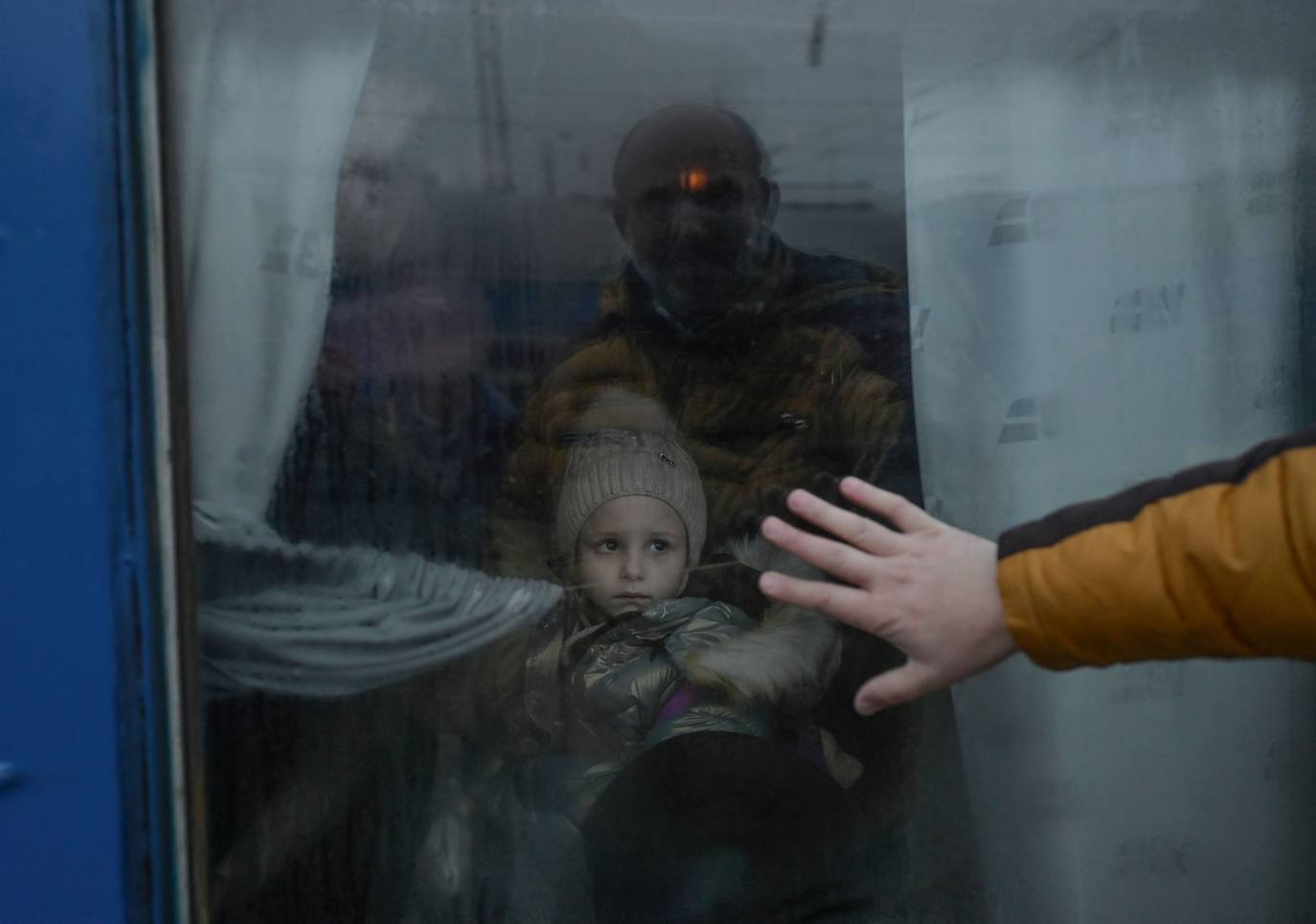 Un padre dice adiós a su hija, poniendo la mano en la ventanilla del tren en el que partirá. La foto fue tomada en Odessa el 7 de marzo de 2022. 