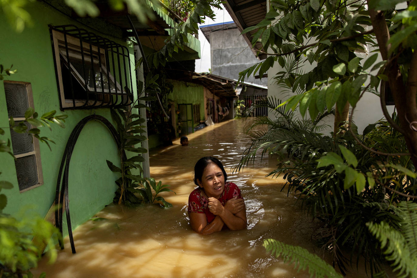 Una mujer trata de atravesar una inundación profunda después del súper tifón Noru, en San Ildefonso, provincia de Bulacan, Filipinas. 