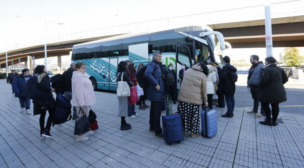 Pasajeros del Alvia que tenía que salir a las 14.45 horas de Gijón se suben al autocar que les trasladó a León. 