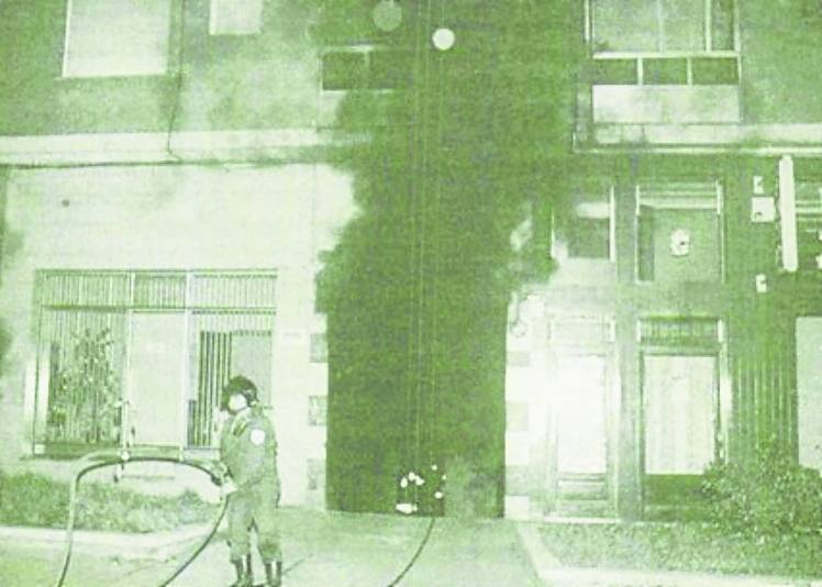 Un bombero trabaja ante la puerta de acceso al garaje.