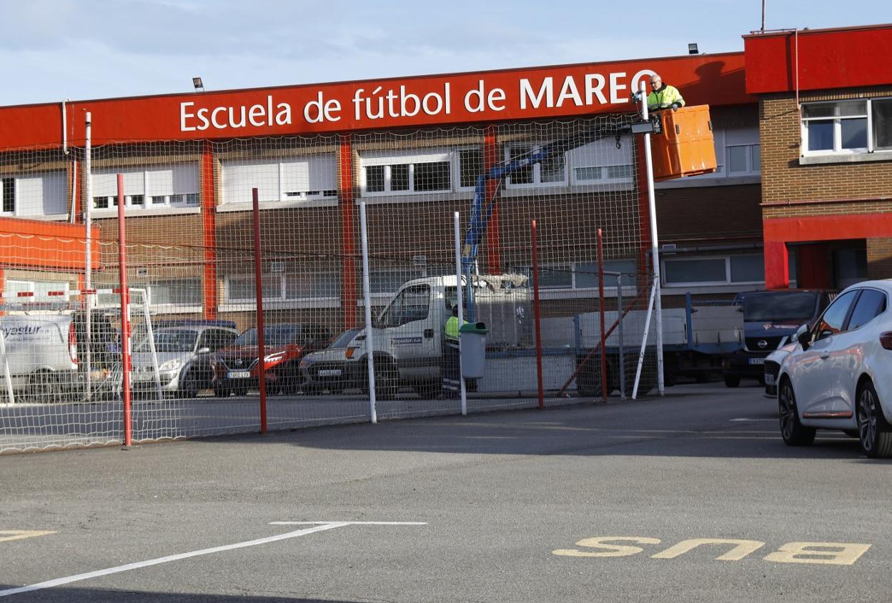 Un operario, subido ayer a una grúa, trabajando para retirar parte del sistema de iluminación de la pista. 