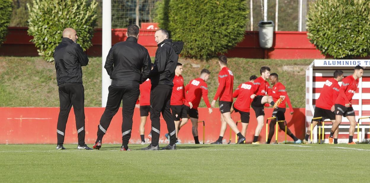 Abelardo, Borja de Matías y Tomás Hervás, dialogando ayer, con los futbolistas calentando en el inicio de la sesión en Mareo.