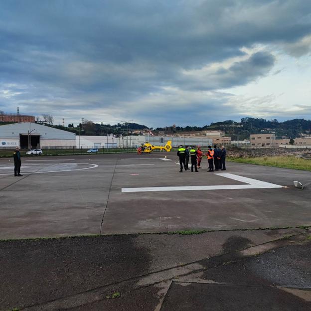 Policías y efectivos de Salvamento Marítimo en la base del Helimer en El Musel. 