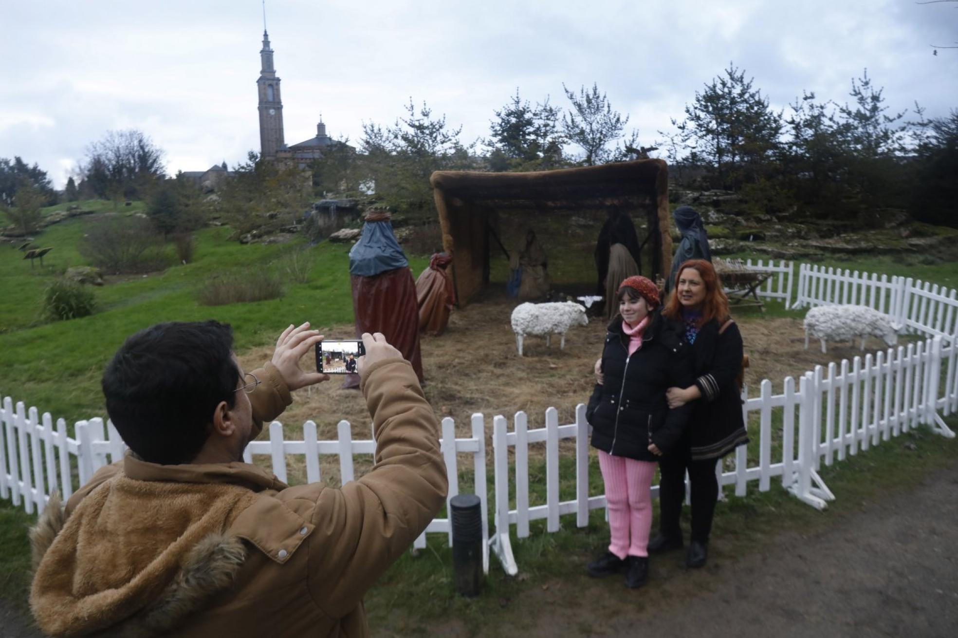 Una familia sacándose una foto ante el Belén del Botánico.