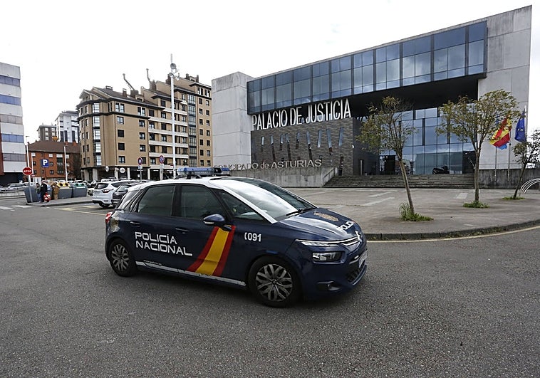 Un coche de la Policía Nacional, este sábado, frente al Palacio de Justicia de Gijón, por donde pasaron los investigados para luego ingresar en prisión.