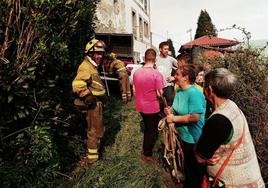 Vecinos de Porciles, en Tineo, conversan con los efectivos de la BRIF desplazados hasta la zona para sofocar el incendio.