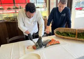 Manuel de la Vega, encargado de la cocina del Grupo El Campanu, trocea el campanu, junto a Adrián Mori, en el restaurante de Ribadesella.