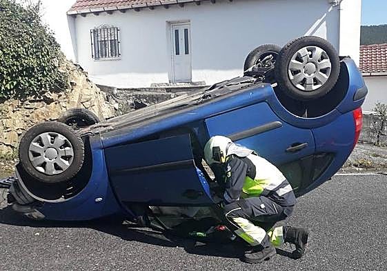 Un bombero revisa el vehículo accidentado.